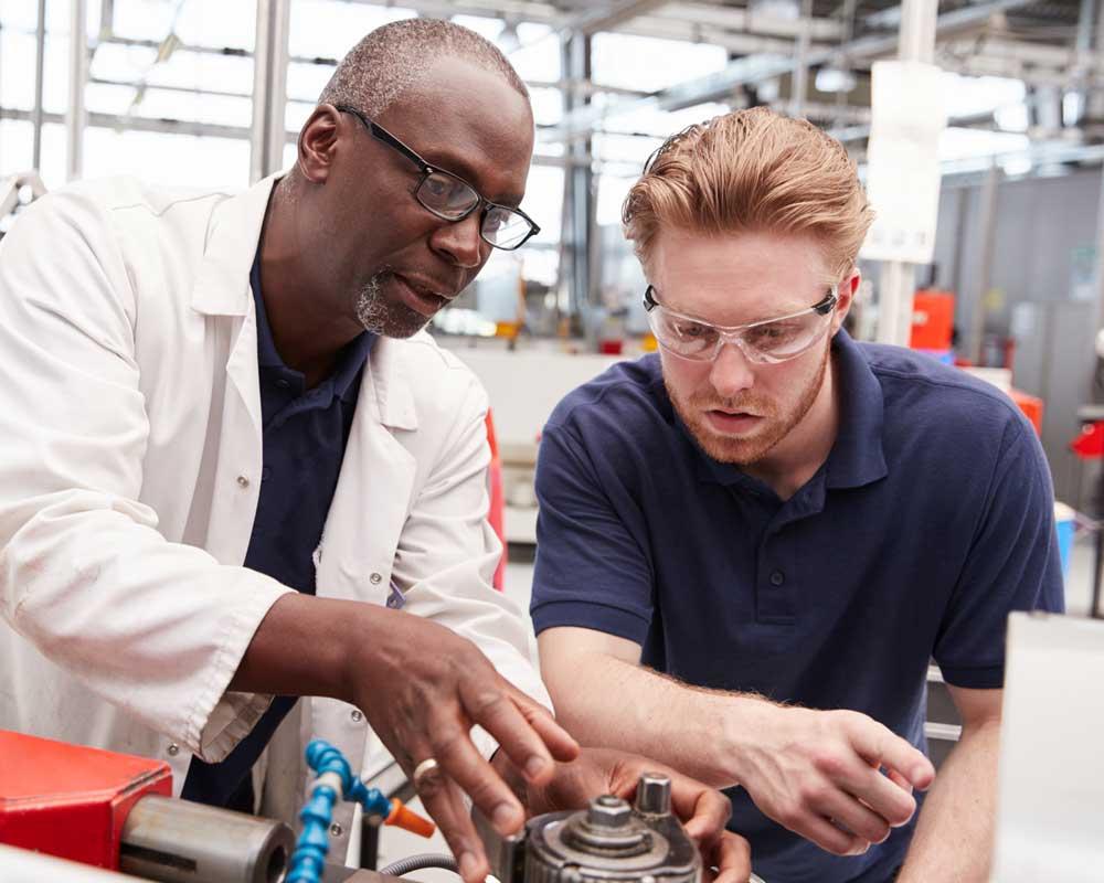 Manufacturing engineers discuss a problem with a machine