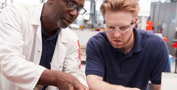 Manufacturing engineers discuss a problem with a machine