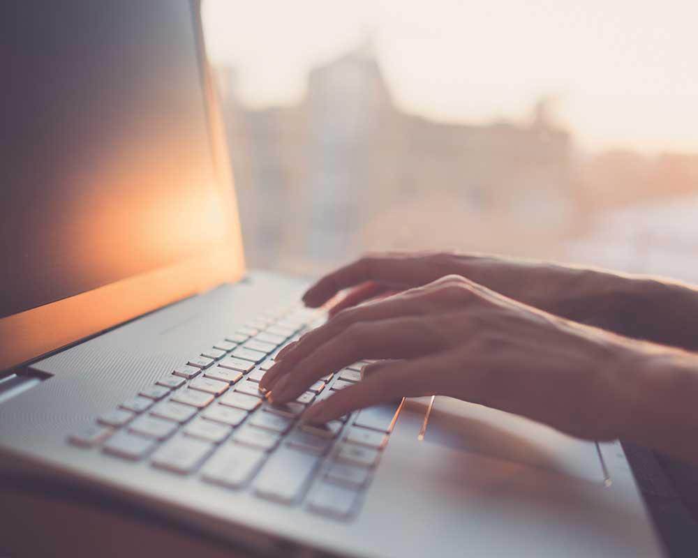 Hands typing on laptop keyboard