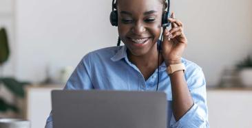Brokerage Support Officer sitting at a laptop wearing headphones