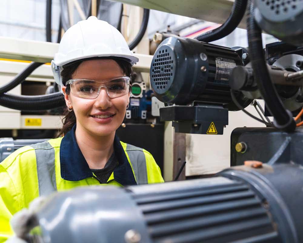 Production technician in front of machinery