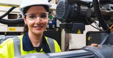 Production technician in front of machinery
