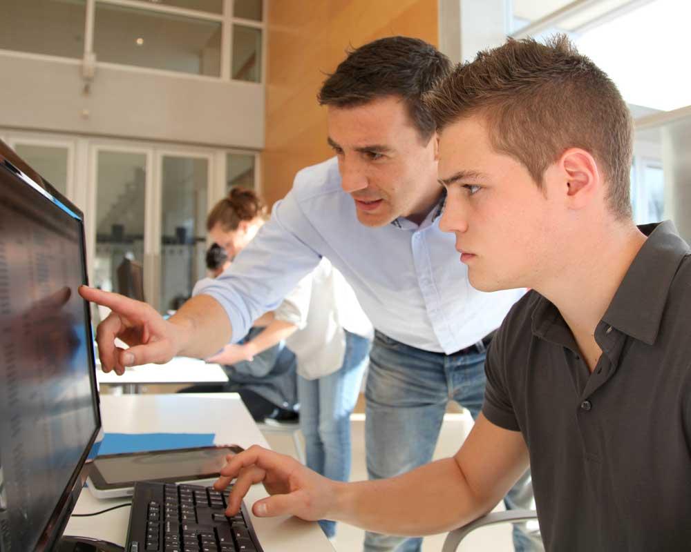 Admin assistant looking at computer screen with a colleague