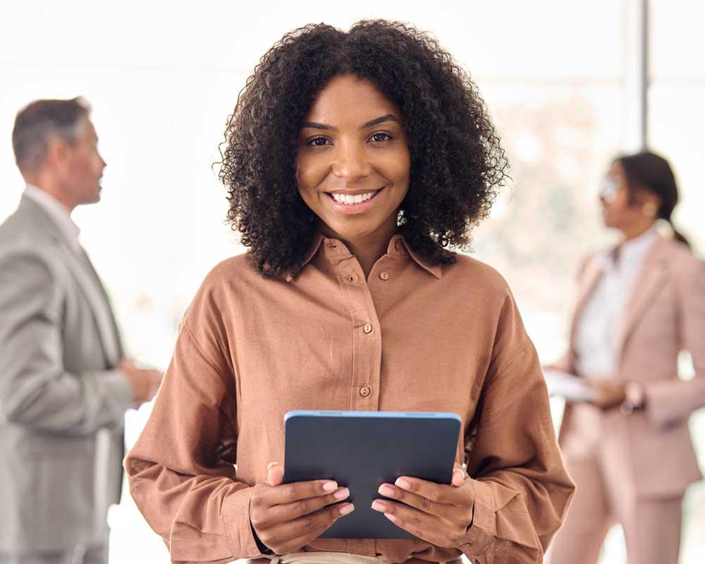 HR apprentice holding a tablet, 2 office workers standing behind