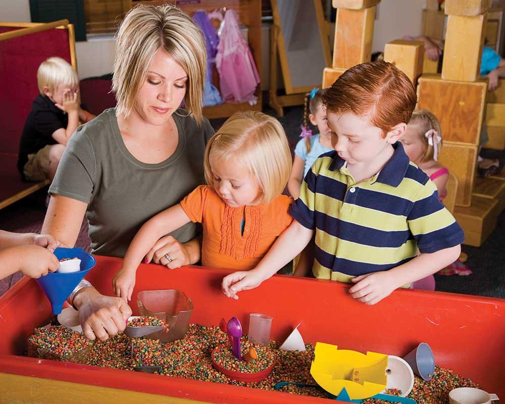 Playworker with 2 children and toys
