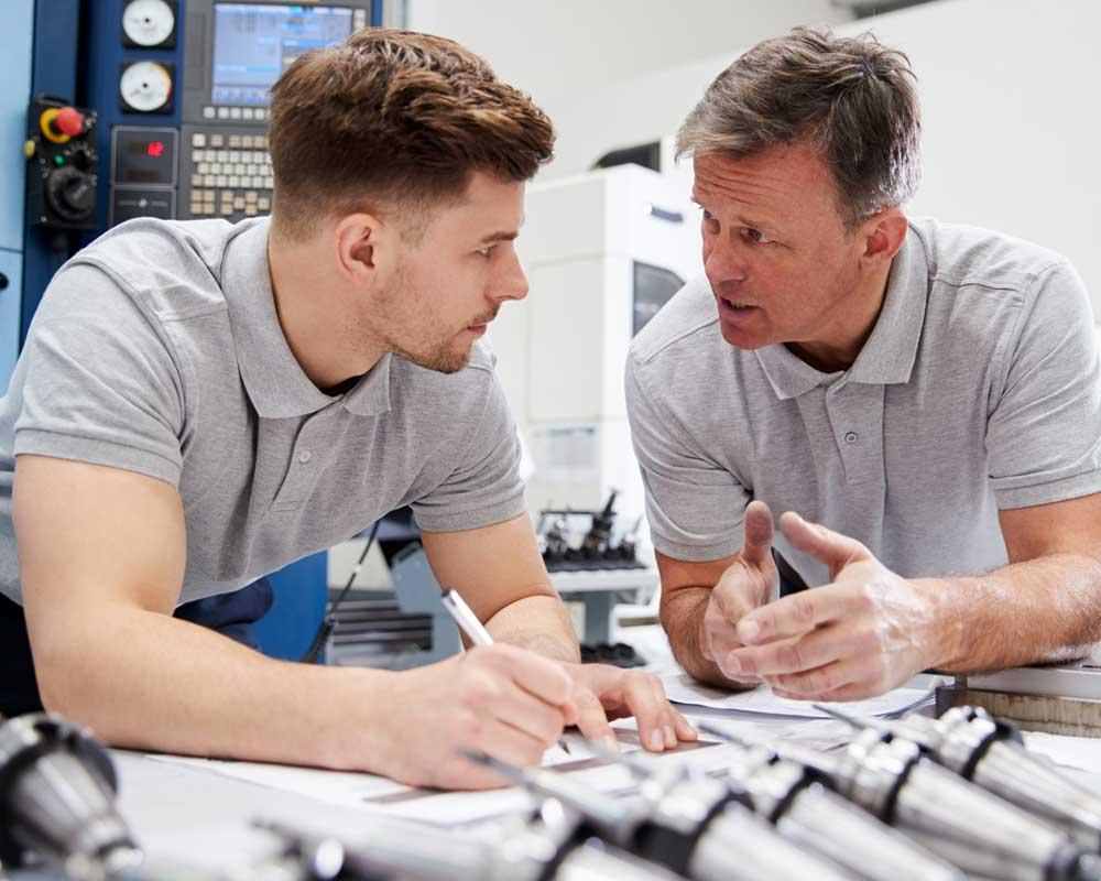 Two engineers discussing the design of parts
